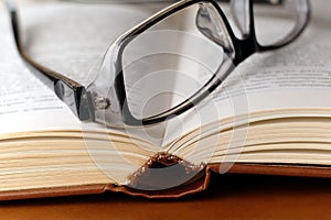 Eyeglasses on open harcover book photo