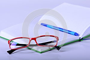 Eyeglasses and paper notebook