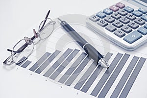 Eyeglasses, pen, chart document and calculator