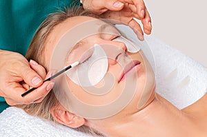Eyelash care treatment procedures. Woman doing eyelashes lamination, staining, curling, laminating and extension for lashes