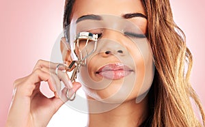 Eyelash curler, woman and beauty in studio for face, skincare and cosmetics routine on pink background. Closeup of