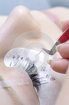 Eyelash extension procedure. Beautiful woman with long eyelashes in a beauty salon.