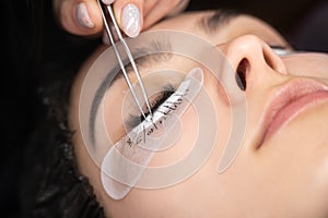 Eyelash extension procedure. Beautiful woman with long eyelashes in a beauty salon. Lashes