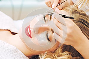 Eyelash extension procedure in beauty salon.