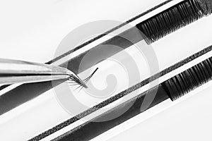 Eyelash extension procedure. Lashes tweezers set macro photo, isolated white background