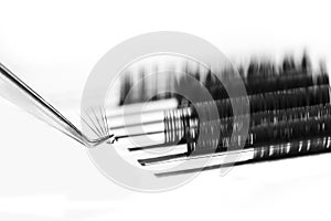 Eyelash extension procedure. Lashes tweezers set macro photo, isolated white background