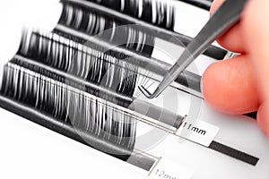 Eyelash extension procedure. Lashes tweezers set macro photo,  white background