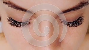 Eyelash Extension Procedure. Woman Eye with Long Blue Eyelashes. Ombre effect. Close up, selective focus.