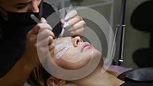 Eyelash Extension Procedure. Woman Eye with Long Eyelashes.