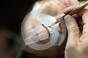 Eyelash extension procedure. woman eye with long eyelashes.