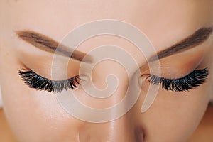 Eyelash Extension Procedure. Woman Eye with Long Eyelashes. Close up, selective focus.