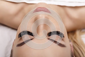 Eyelash Extension Procedure. Woman Eye with Long Eyelashes. Close up, selective focus. Hollywood, russian volume