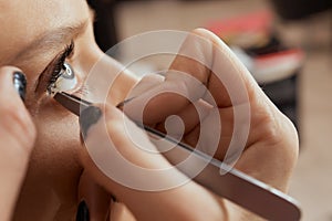 Eyelash Extension Procedure. Woman Eye with Long Eyelashes. Lashes. Close up, selected focus.