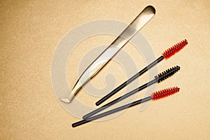 Eyelash extension tools on a gold background