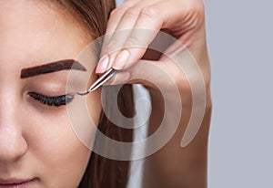 Eyelash removal procedure close up. Beautiful Woman with long lashes in a beauty salon.