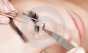 Eyelash removal procedure close up. Beautiful Woman with long lashes in a beauty salon