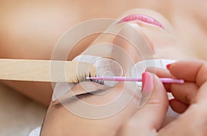 Eyelash removal procedure close up. Beautiful Woman with long lashes in a beauty salon.