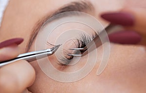 Eyelash removal procedure close up. Beautiful Woman with long lashes in a beauty salon