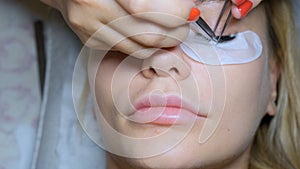 Eyelash removal procedure close up. Beautiful Woman with long lashes in a beauty salon. Eyelash extension.