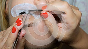 Eyelash removal procedure close up. Beautiful Woman with long lashes in a beauty salon. Eyelash extension.