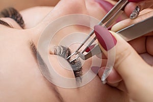 Eyelash removal procedure close up. Beautiful Woman with long lashes in a beauty salon.