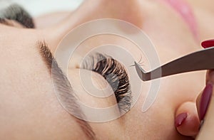 Eyelash removal procedure close up. Beautiful Woman with long lashes in a beauty salon.