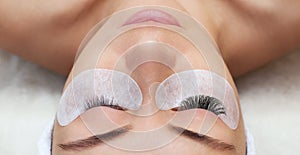 Eyelash removal procedure close up. Beautiful Woman with long lashes in a beauty salon. photo