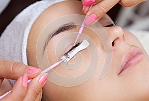 Eyelash removal procedure close up. Beautiful Woman with long lashes in a beauty salon