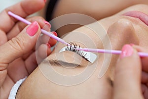 Eyelash removal procedure close up. Beautiful Woman with long lashes in a beauty salon.