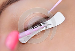 Eyelash removal procedure close up. Beautiful Woman with long lashes in a beauty salon.