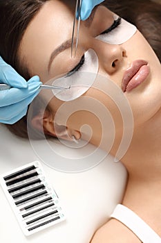 Eyelashes extensions. Fake eyelashes. Eyelash extension procedure.Close up portrait of woman eye with long eyelashes