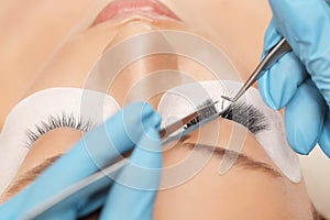 Eyelashes extensions. Fake eyelashes. Eyelash extension procedure.Close up portrait of woman eye with long eyelashes