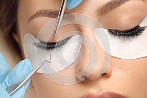 Eyelashes extensions. Fake eyelashes. Eyelash extension procedure.Close up portrait of woman eye with long eyelashes