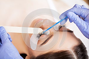 Eyelashes extensions. Fake Eyelashes. Eyelash Extension Procedure. Professional stylist lengthening female lashes