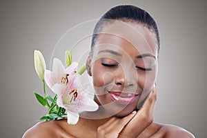 Eyes closed, flower and black woman with cosmetics, skincare and treatment on white studio background. African person