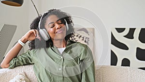 Eyes closed and with serene expression, the woman enjoys a moment of relaxation with her headphones