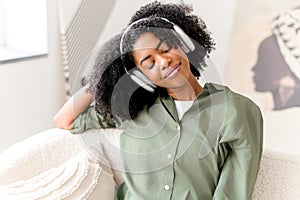 Eyes closed and with serene expression, the woman enjoys a moment of relaxation with her headphones on
