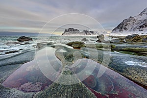 The eyes of the dragon, in the beautiful and amazing Uttakleiv Beach. Lofoten Islands in Norway, Winter landscape. Travel destinat