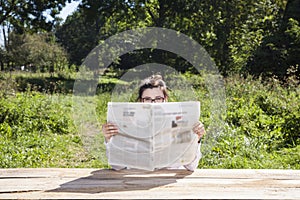 Eyes protrude a newspaper