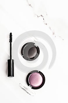 Eyeshadows, black liner and mascara on marble background, eye shadows cosmetics as glamour make-up products for luxury beauty