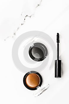 Eyeshadows, black liner and mascara on marble background, eye shadows cosmetics as glamour make-up products for luxury beauty