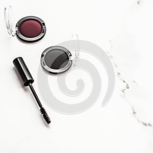 Eyeshadows, black liner and mascara on marble background, eye shadows cosmetics as glamour make-up products for luxury beauty