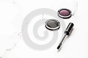 Eyeshadows, black liner and mascara on marble background, eye shadows cosmetics as glamour make-up products for luxury beauty