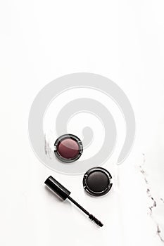 Eyeshadows, black liner and mascara on marble background, eye shadows cosmetics as glamour make-up products for luxury beauty