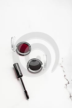 Eyeshadows, black liner and mascara on marble background, eye shadows cosmetics as glamour make-up products for luxury beauty