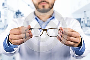 Eyesight care concept - optician giving new optical glasses