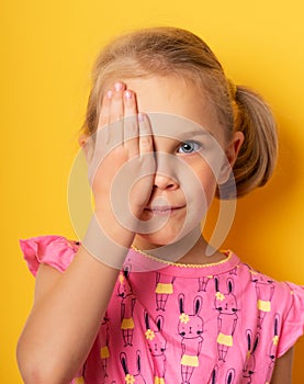 Eyesight check. girl covering one eye with hand. ophthalmology concept.