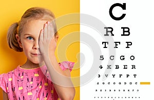 Eyesight check. girl covering one eye with hand. ophthalmology concept.
