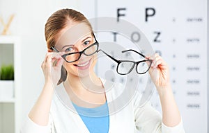 Eyesight check. woman choose glasses at doctor ophthalmologist o