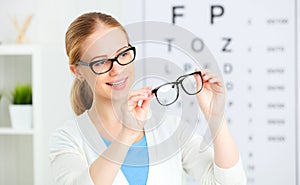 Eyesight check. woman choose glasses at doctor ophthalmologist o